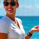 Professional yacht stewardess gracefully serving drinks on a superyacht deck.
